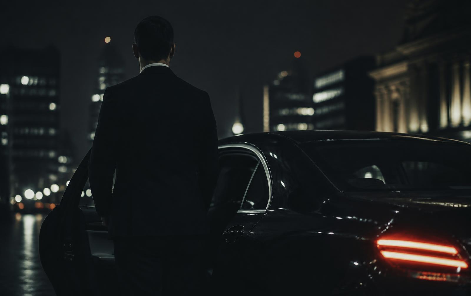 A protective officer walking a client through a quiet London street at night